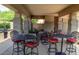 Charming outdoor dining area with wrought iron tables and chairs, perfect for entertaining guests and enjoying nature at 7318 E Woodsage Ln, Scottsdale, AZ 85258