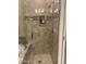 Walk in shower with tile surround, decorative stone border and glass door at 7318 E Woodsage Ln, Scottsdale, AZ 85258