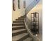 Curved staircase with decorative iron railing, shelf and wall art at 7318 E Woodsage Ln, Scottsdale, AZ 85258