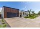 Contemporary home showcasing a spacious driveway and a striking wood-paneled garage, complemented by desert landscaping at 7325 E Virginia Ave, Scottsdale, AZ 85257