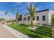 A modern home with a pristine lawn, complemented by desert landscaping, and a stylish black garage door at 7325 E Virginia Ave, Scottsdale, AZ 85257