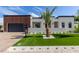 Beautiful modern home featuring a well-manicured lawn, stylish landscaping, and a sleek black garage door at 7325 E Virginia Ave, Scottsdale, AZ 85257