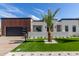 Beautiful modern home featuring a well-manicured lawn, stylish landscaping, and a sleek black garage door at 7325 E Virginia Ave, Scottsdale, AZ 85257
