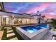 Beautiful backyard pool with a spa and ample space for entertaining, set against a colorful sunset sky at 7325 E Virginia Ave, Scottsdale, AZ 85257