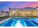 Beautiful pool area with modern design, integrated spa, and lush backyard landscaping at twilight at 7325 E Virginia Ave, Scottsdale, AZ 85257
