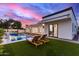 Backyard pool area with lounge seating, surrounded by green grass and a modern house design at 7325 E Virginia Ave, Scottsdale, AZ 85257