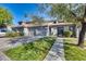 Charming condo with multi-car garage and lush front yard showcasing a well-maintained sidewalk under a sunny sky at 7401 W Arrowhead Clubhouse Dr # 2007, Glendale, AZ 85308