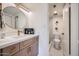 Stylish bathroom featuring a round mirror, modern vanity with gold fixtures, and a separate toilet room at 7430 E Chaparral Rd # A243, Scottsdale, AZ 85250