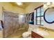 This bathroom features a stone shower with glass door, wood blinds, granite counter and decorative painting at 7705 E Doubletree Ranch Rd # 36, Scottsdale, AZ 85258