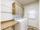 Functional laundry room with overhead cabinets, folding counter, appliances, and door to the backyard at 7705 E Doubletree Ranch Rd # 36, Scottsdale, AZ 85258