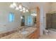 Bathroom features a granite countertop, a large mirror, custom lighting, and a glass enclosed shower and tub at 8262 E Vista De Valle --, Scottsdale, AZ 85255