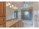 Bathroom with wood cabinets, granite countertops, and a framed shower door at 8262 E Vista De Valle --, Scottsdale, AZ 85255