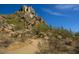 Hiking path through a desert landscape with cactus, boulders, and a blue sky on the horizon at 8262 E Vista De Valle --, Scottsdale, AZ 85255