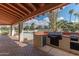 Covered outdoor kitchen with built-in grill, bar seating, and brick flooring, perfect for entertaining at 8262 E Vista De Valle --, Scottsdale, AZ 85255