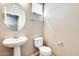 Modern half-bathroom features pedestal sink, large round mirror, and neutral color palette at 900 S 94Th St # 1204, Chandler, AZ 85224