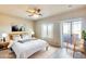 Bright, modern bedroom with a queen bed, side tables, and a sliding door to a balcony with natural light at 900 S 94Th St # 1204, Chandler, AZ 85224