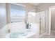 Bright bathroom features a soaking tub with jets and a separate glass-enclosed shower for relaxation and convenience at 9295 W Wood Dr, Peoria, AZ 85381