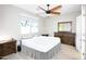 Neutral bedroom with a ceiling fan, window, and wooden furniture provides a relaxing and comfortable atmosphere at 9295 W Wood Dr, Peoria, AZ 85381
