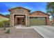 Charming home with a stone-accented entryway, desert landscaping, and a two-car garage at 9295 W Wood Dr, Peoria, AZ 85381
