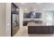 Modern kitchen featuring stainless steel appliances, dark wood cabinets, and a large island with pendant lighting at 9295 W Wood Dr, Peoria, AZ 85381