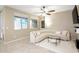 Inviting living room with a curved sofa, tile flooring, and natural lighting at 9295 W Wood Dr, Peoria, AZ 85381
