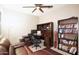 Inviting home office with a ceiling fan, desk, bookcase, and comfortable seating area at 9295 W Wood Dr, Peoria, AZ 85381