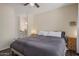 Bedroom with a ceiling fan and dark floors leading to an adjacent bathroom at 9451 E Becker Ln # 1041, Scottsdale, AZ 85260
