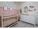 Bedroom with white crib and changing table with floral wallpaper and rose colored walls at 9451 E Becker Ln # 1041, Scottsdale, AZ 85260