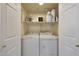 Laundry room featuring a front loading washer and dryer unit with white cabinets and shelves at 9451 E Becker Ln # 1041, Scottsdale, AZ 85260