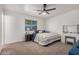 This bedroom features a ceiling fan, a vanity, and a window with natural light at 9903 N 87Th Dr, Peoria, AZ 85345