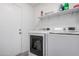 This laundry room features a modern washer and dryer, shelving, and access to outside at 9903 N 87Th Dr, Peoria, AZ 85345