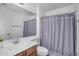 Well-lit bathroom featuring a vanity, toilet, and shower with a stylish curtain at 10132 E Isleta Ave, Mesa, AZ 85209