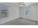 Bright bedroom features a ceiling fan, neutral carpet, and two windows at 10132 E Isleta Ave, Mesa, AZ 85209