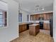 Spacious kitchen with granite counters, an island, brown cabinets, and black appliances at 10132 E Isleta Ave, Mesa, AZ 85209