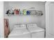 Functional laundry room with modern washer and dryer, plus shelving for storage at 10132 E Isleta Ave, Mesa, AZ 85209