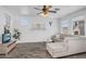 Bright living room featuring wood floors, a ceiling fan, and a comfortable neutral-toned sectional sofa at 10132 E Isleta Ave, Mesa, AZ 85209