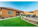 Relaxing backyard space featuring artificial turf, an outdoor seating area, and lush plants at 10251 W Gambit Trl, Peoria, AZ 85383