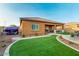 Beautiful backyard with artificial turf, a covered patio, and lovely landscaping at 10251 W Gambit Trl, Peoria, AZ 85383