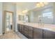 The bathroom is equipped with a dual sink vanity, large framed mirror, and a view of the walk-in shower at 10251 W Gambit Trl, Peoria, AZ 85383
