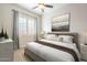 This bedroom offers a relaxing space with natural light, complemented by neutral tones and ceiling fan at 10251 W Gambit Trl, Peoria, AZ 85383