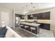 Modern kitchen with dark wood cabinets, stainless steel appliances, and a spacious island with seating at 10251 W Gambit Trl, Peoria, AZ 85383