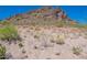 Desert landscape with rocky terrain, native vegetation, and a mountain backdrop under a clear blue sky at 10251 W Gambit Trl, Peoria, AZ 85383