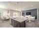 Open-concept living area with a large kitchen island, modern lighting, and stylish furnishings at 10251 W Gambit Trl, Peoria, AZ 85383