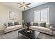 Bright living area featuring comfortable couches, a stylish coffee table, and contemporary decor at 10251 W Gambit Trl, Peoria, AZ 85383