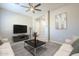 A spacious living room featuring an elegant ceiling fan, modern decor, and stylish furniture at 10251 W Gambit Trl, Peoria, AZ 85383