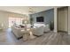 Bright living room with neutral tones, a ceiling fan, and sliding glass doors leading to an outdoor patio at 10251 W Gambit Trl, Peoria, AZ 85383