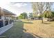 Spacious backyard with a covered patio, lush grass, and mature trees provides privacy and outdoor enjoyment at 10326 W Kingswood Cir, Sun City, AZ 85351