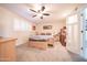 Bedroom with a ceiling fan, window shutters, and carpeted flooring at 10326 W Kingswood Cir, Sun City, AZ 85351