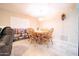 Cozy dining area featuring a wooden table with seating, a charming light fixture, and tile flooring at 10326 W Kingswood Cir, Sun City, AZ 85351