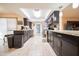 Spacious kitchen featuring dark cabinetry, modern appliances, granite countertops, and tile flooring at 10326 W Kingswood Cir, Sun City, AZ 85351